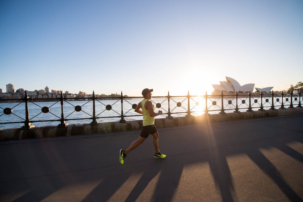biegający mężczyzna z Operą w Sydney w tle